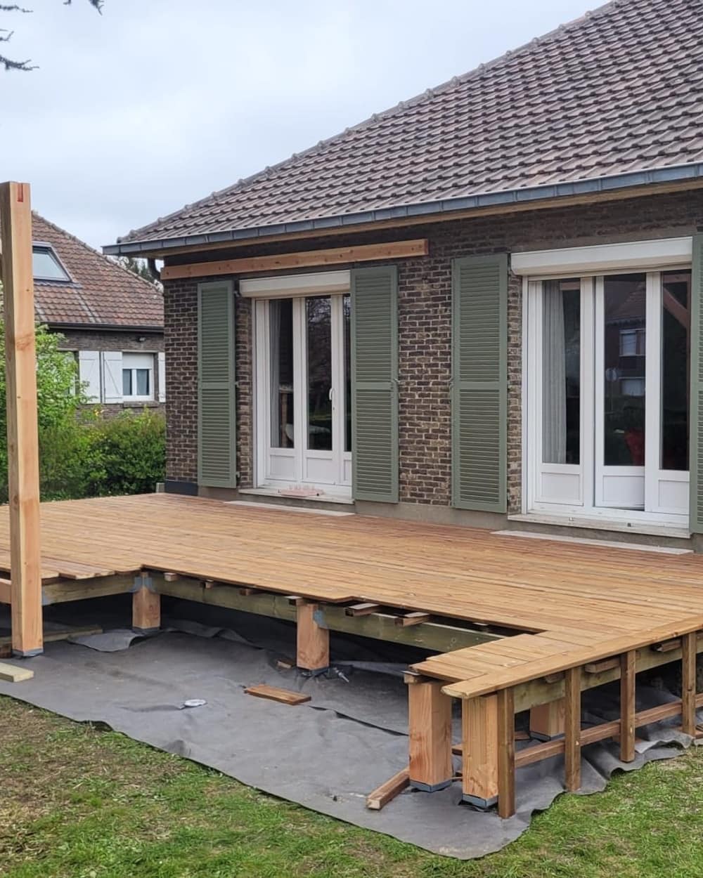 Les lames de la terrasse posées sur toute la façade de la maison