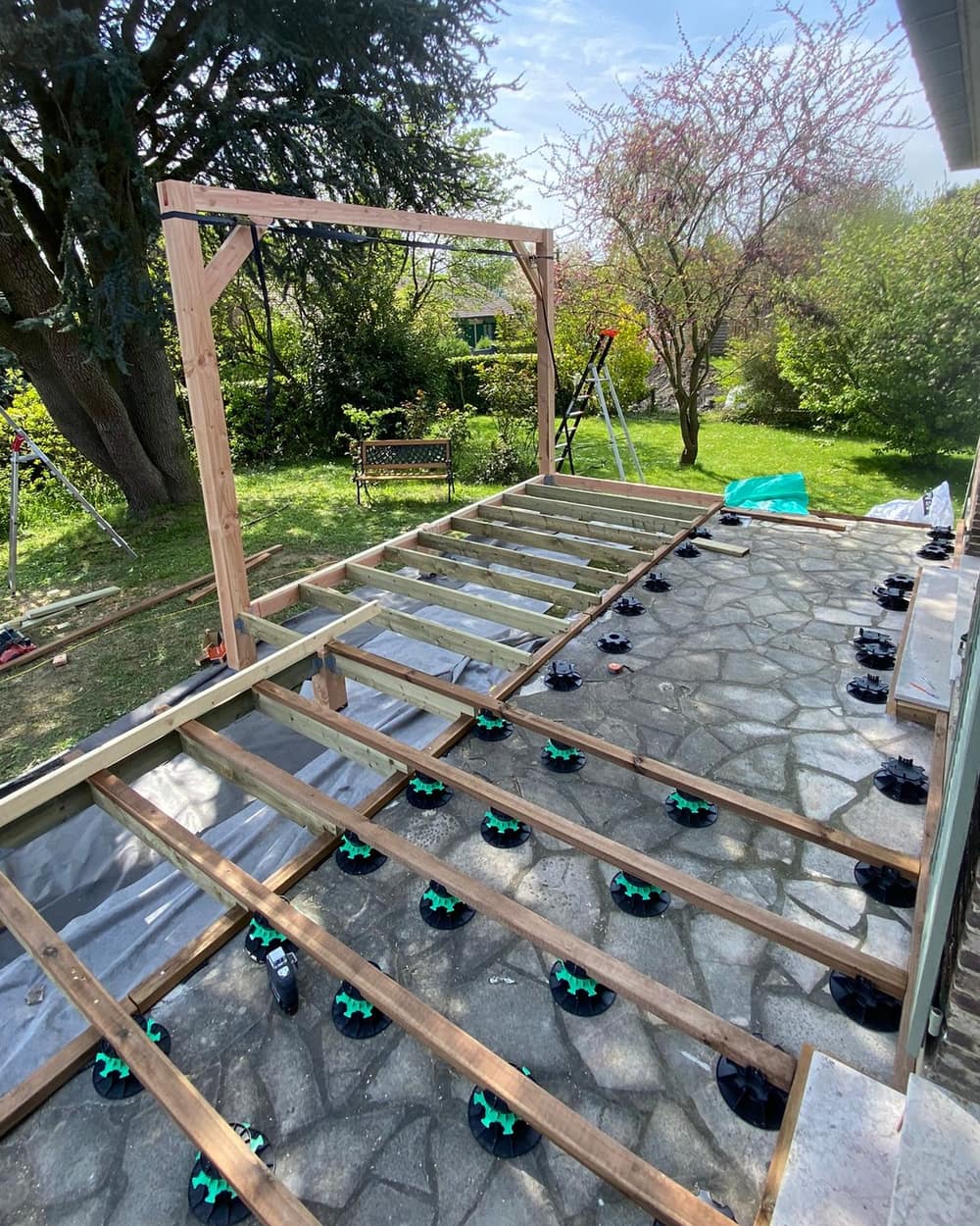 La structure de la terrasse posée sur l'ancienne dalle, avec les poteaux de la pergola