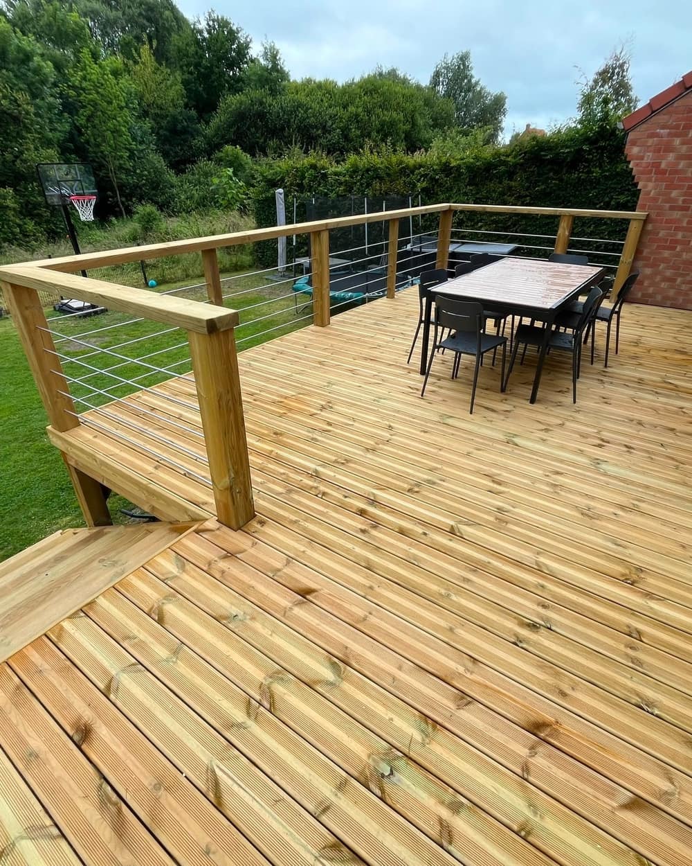 Le plateau fini de la terrasse sur pilotis avec sa table, vue sur le jardin